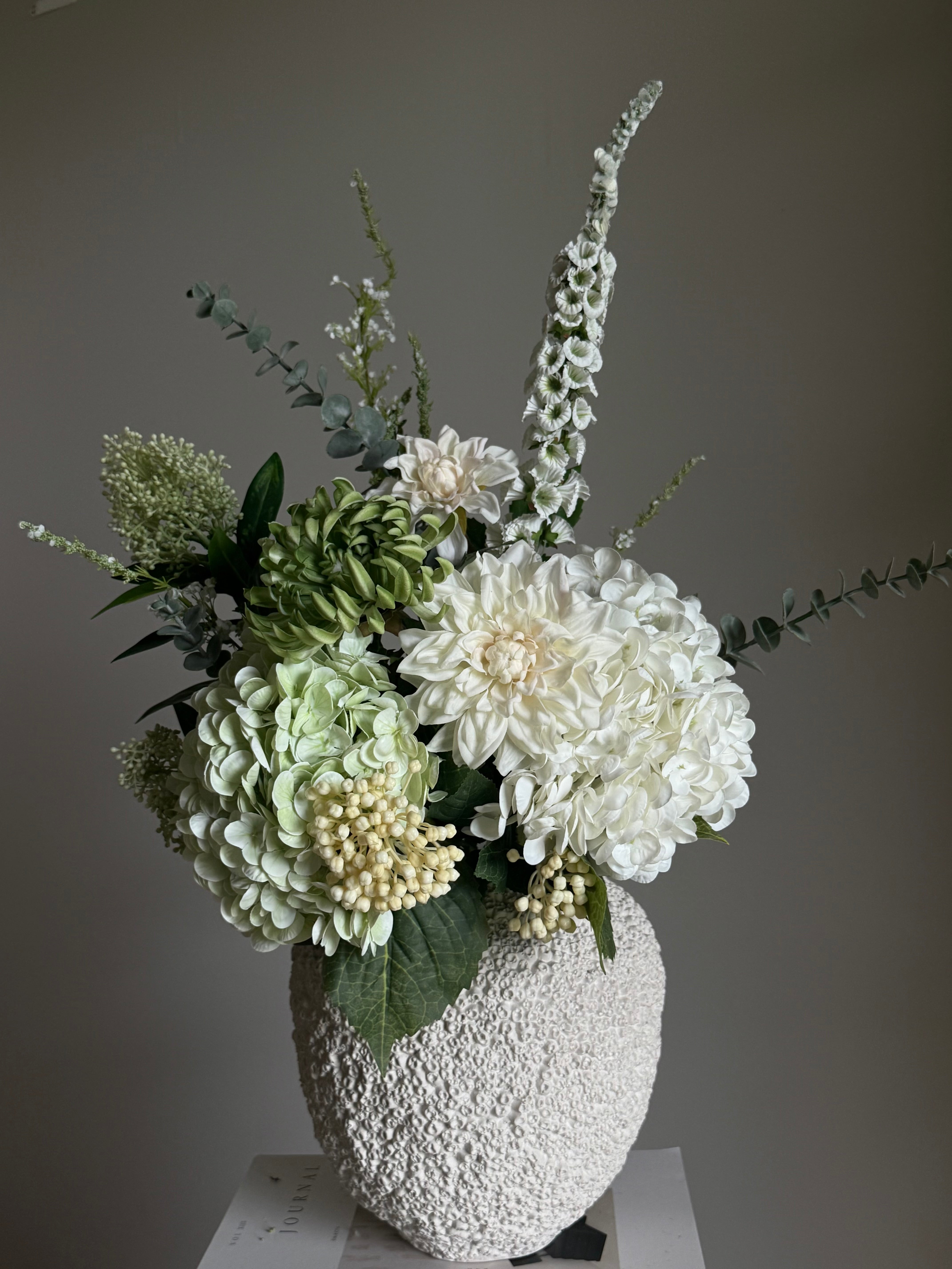 Revebjelle hvit kunstig stilk med hvite blomster og grønne detaljer i elegant oppsats