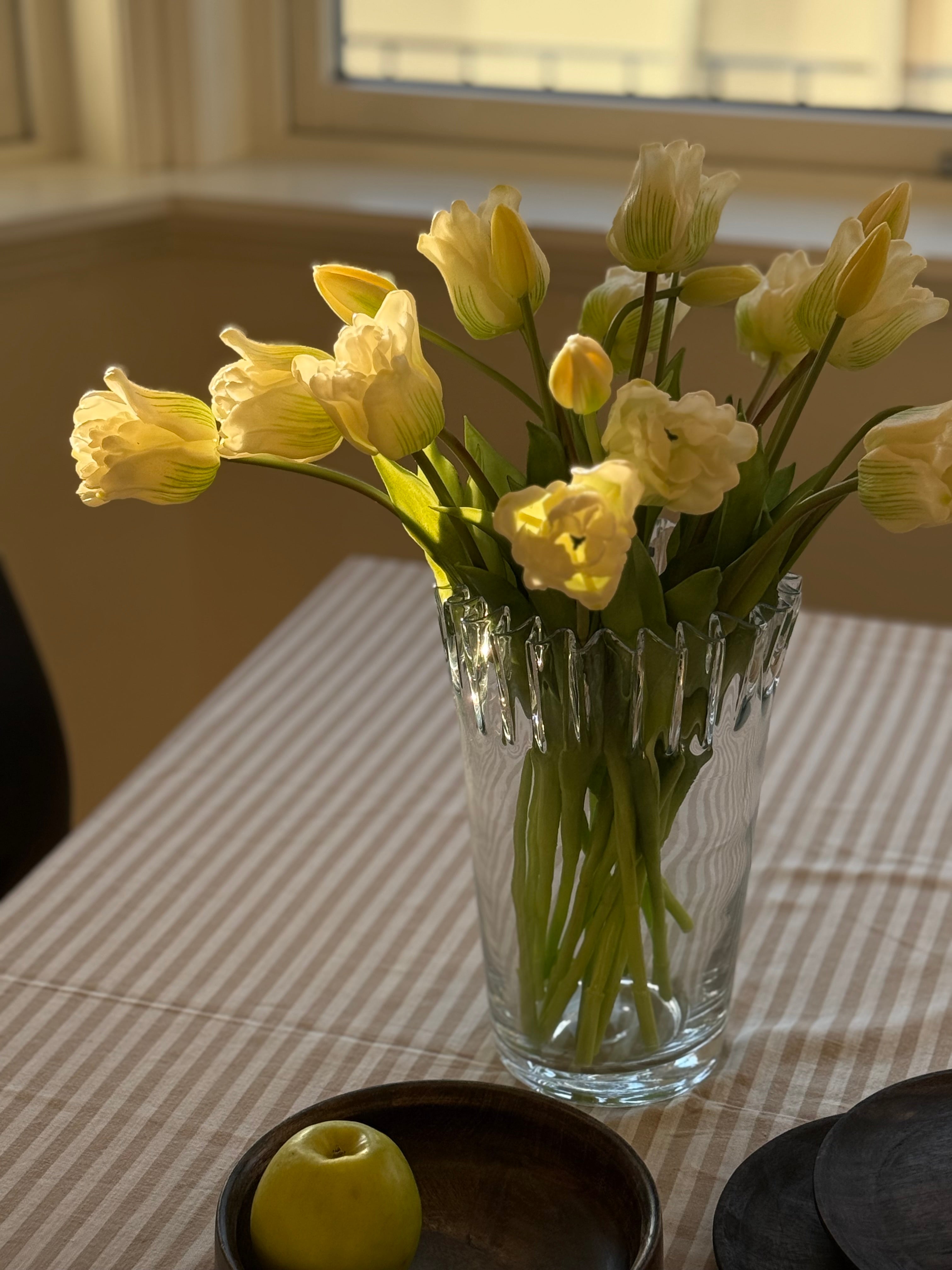 Tulipanvase glass plassert på vinduskarm – lys gjennom transparent glassoverflate