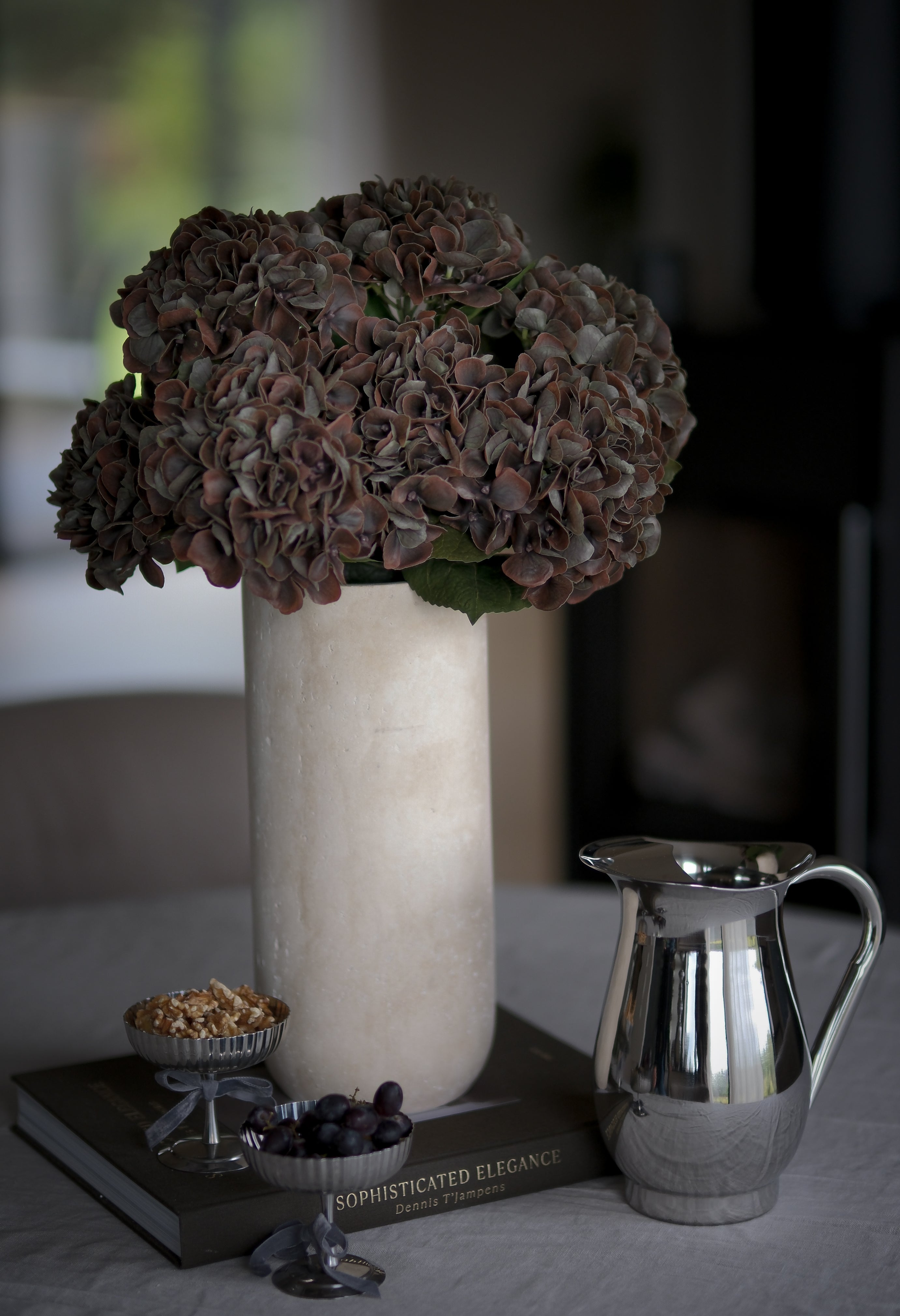 Kunstig hortensia mørk brun i stilbent interiør, naturlig stilkform og dype bruntoner