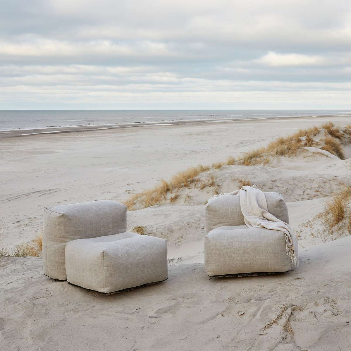 Soft hjørnesofa sand i hageomgivelser – integrert bærestropp synlig på sandfarget sofa