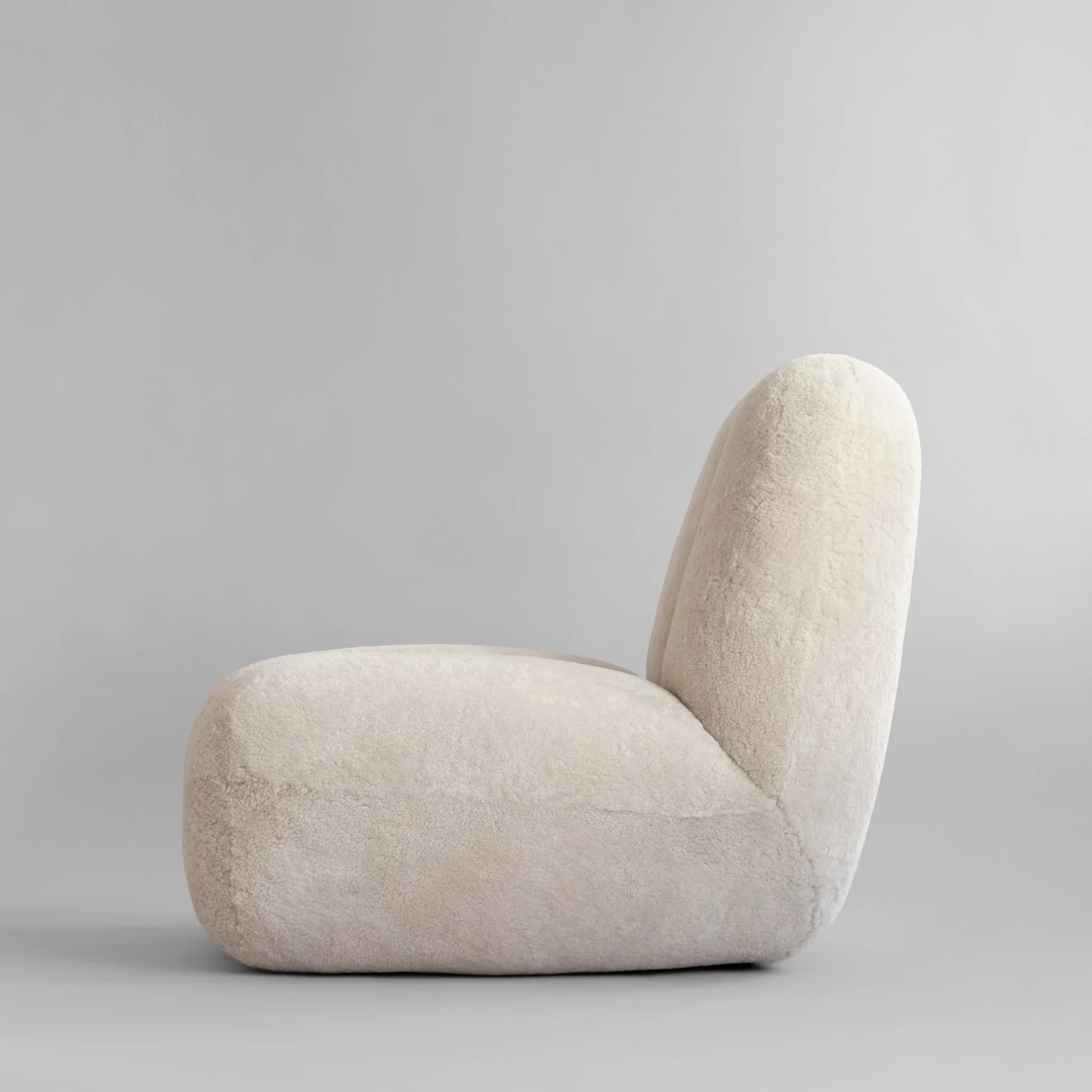 Toe Chair loungestol Sandshell saueskinn – nærbilde av riflet tekstur og myk overflate i varm sandtone